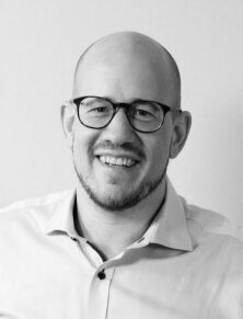 Schwarz Weiß Bild eines Herren mit sehr kurzen Haaren und Brille, Dreitage Bart